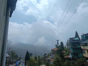 a view of a mountain with clouds in the sky at Cloud Hill Homestay in Jālāpahār