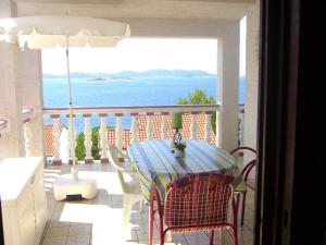 a table and chairs on a balcony with a view of the ocean at Apartment Branko in Drage