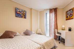 a bedroom with a bed and a desk and a window at Patacona By The Beach in Valencia