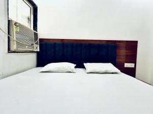 a large white bed with two pillows on it at Shri charno amrit vatika in Vrindāvan