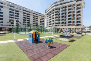 a playground in front of a large building at Patacona By The Beach in Valencia