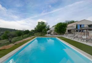 a swimming pool in a yard with a house at Le Loft in Esparron