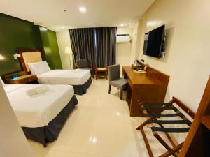a hotel room with two beds and a desk at Hotel Herencia 625 in Locsin