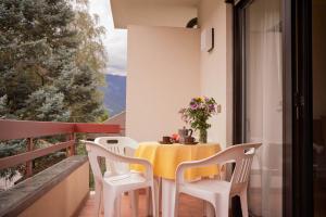 a table and chairs on a balcony with a table and flowers at Residence Gerold in Rablà