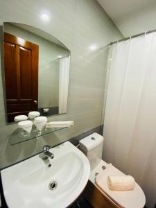 a bathroom with a sink and a toilet and a mirror at Hotel Herencia 625 in Locsin +47 photos