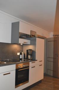 a kitchen with white cabinets and a stove top oven at Ferienwohnung Perlenreut 1 in Piding