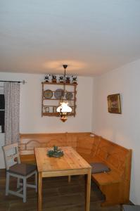 a dining room with a wooden table and a chandelier at Ferienwohnung Perlenreut 1 in Piding