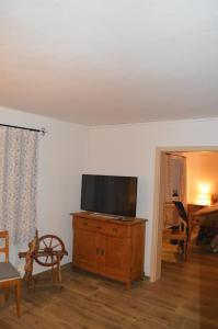 a living room with a flat screen tv on a wooden dresser at Ferienwohnung Perlenreut 1 in Piding