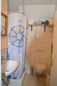 a bathroom with a sink and a toilet and a shower curtain at Ferienwohnung Perlenreut 1 in Piding