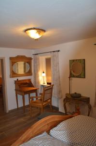 a bedroom with a bed and a table and a desk at Ferienwohnung Perlenreut 1 in Piding