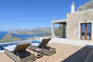 a patio with two chairs and a view of the ocean at Villa Selas Kalymnos in Kalymnos