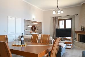 a dining room and living room with a table and a television at Villa Selas Kalymnos in Kalymnos