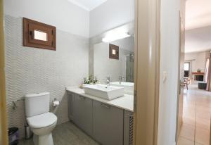 a bathroom with a white sink and a toilet at Villa Selas Kalymnos in Kalymnos +17 photos