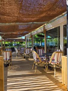 a group of chairs and tables on a deck at Camping Val de Boutonne in Saint-Jean-dʼAngély