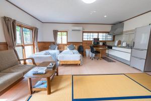 a living room with two beds and a kitchen at ヴィラ結Miyakojima2 in Miyako-jima