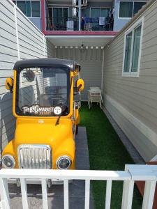 a small yellow golf cart parked next to a building at The big market Resort in Jomtien Beach