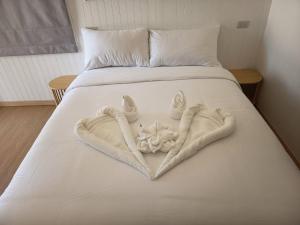 a white bed with a heart made out of towels at The big market Resort in Jomtien Beach
