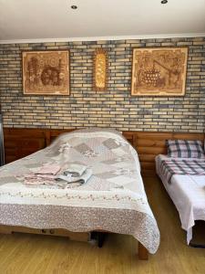 a bedroom with two beds and a brick wall at Будиночок для відпочинку in Odesa