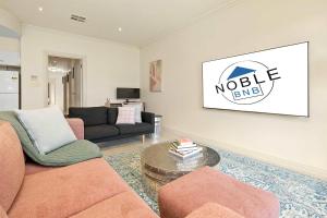 a living room with a couch and a table at Archie's Townhouse 4BD 2BT in Glenunga