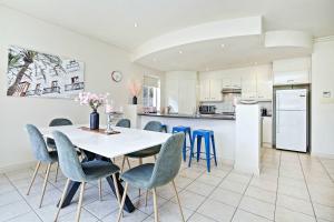 a kitchen and dining room with a table and chairs at Archie's Townhouse 4BD 2BT in Glenunga