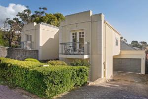 a white house with a fence and bushes at Archie's Townhouse 4BD 2BT in Glenunga