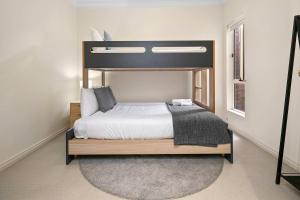 a bedroom with a large bed with a wooden frame at Archie's Townhouse 4BD 2BT in Glenunga