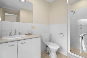 a bathroom with a toilet and a sink and a shower at Archie's Townhouse 4BD 2BT in Glenunga +9 photos