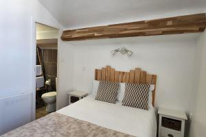 a bedroom with a white bed with a wooden headboard at Hôtel Parc Mazon-Biarritz in Biarritz