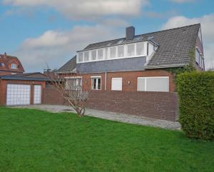 a red brick house with white windows and a yard at Steilsand 1 - 200 M Zum Strand in Cuxhaven
