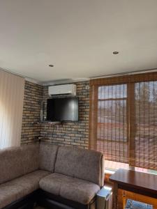 a living room with a couch and a television at Будиночок для відпочинку in Odesa