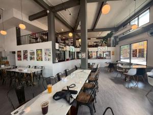a restaurant with tables and chairs in a room at Holmes Pranakorn in Bangkok