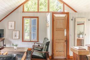 a living room with a table and chairs and a door at The Barn Daylesford in Daylesford +17 photos