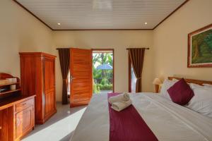a bedroom with a bed with a dresser and a window at Lungguh Penida Hut in Nusa Penida +79 photos