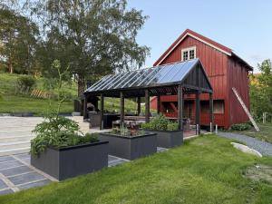 a red barn with plants in front of it at Apartment at NerSalberg Farm in Røra, Inderøy in Røra