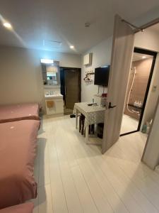 a living room with a couch and a table and a television at Hotel MR TOMO ATAMI 301 in Atami