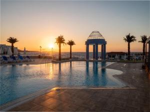 a swimming pool with a gazebo and palm trees at Dome Hotel in Kyrenia