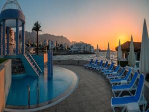 a group of chairs sitting next to a swimming pool at Dome Hotel in Kyrenia