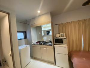 a small kitchen with a sink and a microwave at Hotel MR TOMO ATAMI 301 in Atami