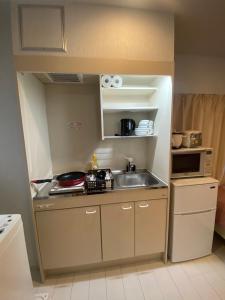 a small kitchen with a sink and a microwave at Hotel MR TOMO ATAMI 301 in Atami +10 photos