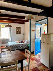 a room with a table and a bed and a table and chairs at Longo maï in Vallon-Pont-dʼArc