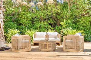 a patio with two wicker chairs and two tables at Villa Claudia Hotel Cannes Centre - Parking in Cannes +58 photos