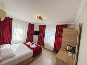 a hotel room with a bed and red curtains at Le Safran Palace in Istanbul