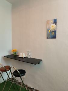 a black shelf on a wall with a table and a chair at Gather inn in George Town