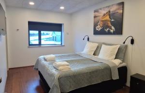 a bedroom with a bed with towels on it at Penthouse by Krambatangi in Øravík