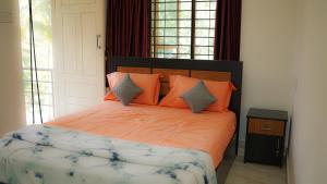 a bedroom with a large bed with orange pillows at Haven Grace in Kovalam