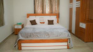 a bedroom with a large bed with a wooden headboard at Haven Grace in Kovalam +7 photos