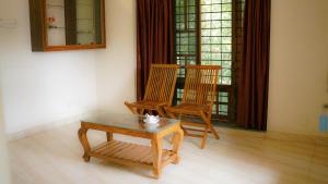 two chairs and a table in a room at Haven Grace in Kovalam