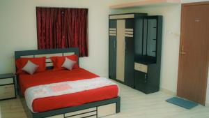 a bedroom with a red bed and a cabinet at Haven Grace in Kovalam