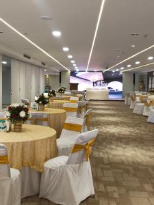 a banquet hall with white tables and white chairs at Keys Lite by Lemon Tree Hotels, Urban Square, Udaipur in Udaipur