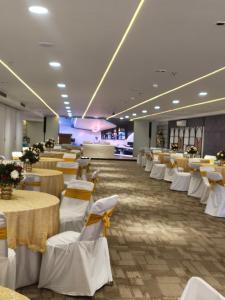 a restaurant with white tables and white chairs at Keys Lite by Lemon Tree Hotels, Urban Square, Udaipur in Udaipur